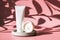 Cosmetic concept. A white tube with a face scrub, tonic or mask and a jar of moisturizer next to it, stand on a concrete podium in