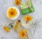 Cosmetic cream, calendula flower soap on concrete background