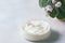 Cosmetic cream and Flowering Saintpaulias, African violet. Mini Potted plant. on a white background wooden table