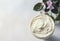 Cosmetic cream and Flowering Saintpaulias, African violet. Mini Potted plant. on a white background wooden table