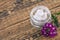 Cosmetic cream, fresh verbena flowers on wooden background