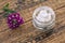 Cosmetic cream, fresh verbena flowers on wooden background