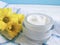 Cosmetic cream organic morning skincare ointment yellow chrysanthemum flower white wooden, daisy, towel