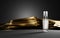 Cosmetic glass transparent spray bottle on dark background with gold silk cloth. Skin care beauty product night serum