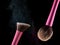 Cosmetic makeup brushes on black background flash explosion splash powder shadow blush.