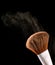 Cosmetic makeup brushes on black background flash explosion splash powder shadow blush.