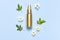 Cosmetic mock up gold bottles. Cosmetics, spring white flowers green leaves on blue background. Cosmetics springtime summer