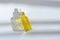 Cosmetic oil in glass bottle with white pipette on white background