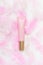 Cosmetic pink tube and feather top view composition. Skincare cosmetology product, moisturizing cream concept. Lotion, concealer
