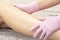 Cosmetic procedure applying cream on legs depilation epilation rubbing cream