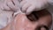 Cosmetic procedure for cleansing teenage facial skin. Close-up of female cosmetologist hands in white gloves squeezing