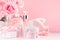Cosmetic products for aromatherapy, spa salon - essential rose oil, bath salt, cream, soap, bath accessories and roses in pink.