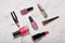 Cosmetic products on marble texture. Lipsticks, nail varnish, makeup brushes on white marble background