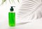 Cosmetic pump dispenser bottle filled with green liquid on white, Palm leaf hard shadows