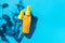 Cosmetic spray bottle blue and yellow with transparent liquid on a blue background. Spa cosmetics. Natural skincare