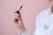 Cosmetic stain on white shirt. In the female hand mascara. isolated on pink background