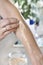 Cosmetic treatment. A woman`s hand puts a balm on her forearm.