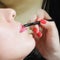 Cosmetician applying lipstick