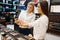 Cosmetician at counter and woman, cosmetics store