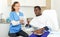 Cosmetician woman with papers talking to man before procedure in clinic