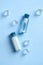 Cosmetics bottles of refreshing shampoo and lotion and ice cubes on blue background top view