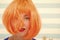 Cosmetics for care and revival. Lady red ginger wig and make up close up. Coloring and treatment professional salon