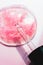 Cosmetics drop macro on pink background. Beauty serum gel laboratory test. Scientific cosmetology
