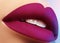 Cosmetics, makeup. Bright lipstick on lips. Closeup of beautiful female mouth with purple lip makeup. Part of face