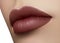 Cosmetics, makeup. Dark fashion lipstick on lips. Closeup beautiful female mouth with lip makeup. Part of face