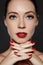 Cosmetics, manicure on nails with bright red polish. Dark red lips make-up and nail color