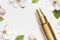 Cosmetics springtime Concept. Cosmetics, spring white flowers green leaves on light background. Cosmetic mock up gold