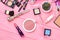 Cosmetics and tools on pink background.