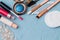 Cosmetics on a turquoise background, lip balm, eye shadow, makeup brushes, professional skin care products