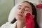 Cosmetologist cleaning face of a patient with cotton pad in beauty and spa salon preparing for procedure