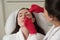 Cosmetologist cleaning face of a patient with cotton pad in beauty and spa salon preparing for procedure