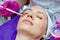 Cosmetologist doctor applies gel to the patient`s face with a brush in a beauty salon. Preparation for the procedure of