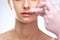 Cosmetologist does injections for lips augmentation and anti wrinkle in the nasolabial folds of a beautiful woman. Women\\\'s