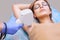 The cosmetologist does the laser hair removal procedure in the armpit zone,