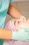 Cosmetologist with gloved hands applies a moisturizing mask with peeling cream on the female face. Facial cosmetology