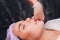 Cosmetologist makes a buccal massage of the patient`s facial muscles.