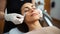 The cosmetologist makes the procedure Microdermabrasion of the facial skin of a beautiful, young woman in a beauty salon.