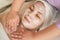 A cosmetologist massages a woman`s face and neck with a moisturizing mask. Close-up. Relaxed Asian woman takes beauty treatments