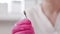 A cosmetologist in medical pink gloves shows a close-up of an abrasive nozzle for filing nails. Slow motion. The concept