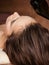 Cosmetologist pours balm for hair on head of  woman. Spa treatments