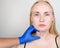 A cosmetologist prepares the patient for surgery: contour plastics of the neck, mesotherapy or botulinum therapy. Wrinkles and