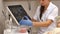 Cosmetologist squeezes cream from a tube on a glass saucer. Hands in medecine gloves