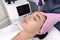 Cosmetology. Beautiful Woman At Spa Clinic Receiving Stimulating Electric Facial Treatment From Therapist. Closeup Of