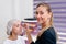 Cosmetology cabinet client sitting on couch. Beautician applies marking on eyebrows