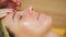 Cosmetology, facial massage. close-up. beautician applies massage honey to woman`s face, rubs it with massage movements