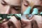 Cosmetology. The process of removing hair between the eyebrows. Teen guy on a cosmetic procedure. Close-up of a teenager`s face.